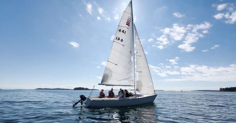 An Able Sail sailboat in the ocean on a sunny day, with Garth Homer Discovery Clients on board.